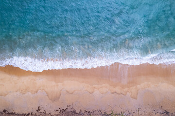 Fototapeta na wymiar Aerial view sandy beach and waves Beautiful tropical sea in the morning summer season image by Aerial view drone shot, high angle view Top down sea waves