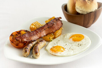 australian breakfast with fried eggs, sausage, bacon and potato