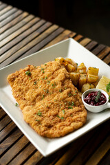 german veal schnitzel cutlet with potato and red berry sauce