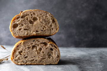 Sourdough artisan homemade bread sliced in halfs on dark background. Copy space