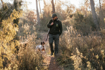 Man hunting with dog in autumn woods