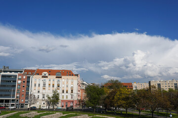 Fototapeta na wymiar Square with houses and trees, blue sky and white cloud