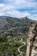 the ruins of an ancient alpine settlement in the mountains of Dagestan against the backdrop of mountains and blue sky
