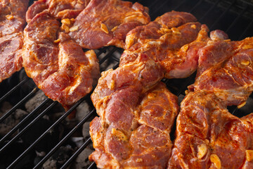 Roasted pork neck. Slices of marinated meat on a barbecue grill.
