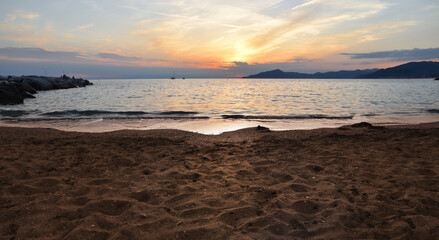 incredible colors and lights, a romantic sunset on the beach facing the sea in the magnificent Liguria