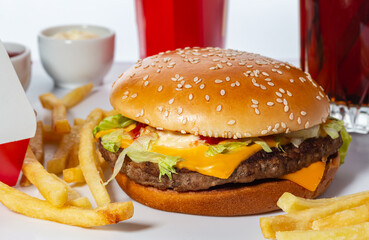 close-up fresh tasty hamburger with french fries and cola, selective focus, side view
