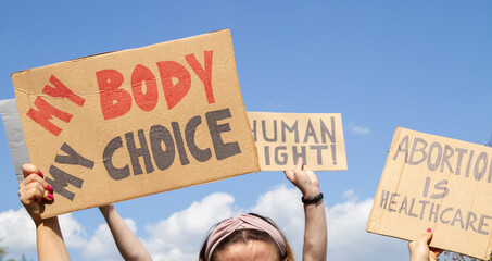 Protesters holding signs My Body My Choice, Abortion Is Healthcare, Human right. People with placards supporting abortion rights at protest rally demonstration. - obrazy, fototapety, plakaty