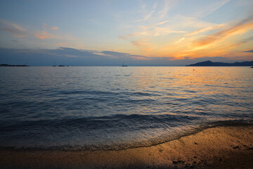 incredible colors and lights, a romantic sunset on the beach facing the sea in the magnificent Liguria