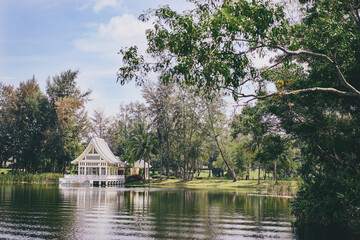 Summer landscape with beautiful white house on the lake shore.