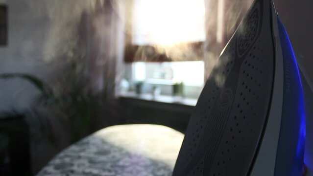 A blue iron blowing off steam in fornt of a bright interior background. Static close up shot