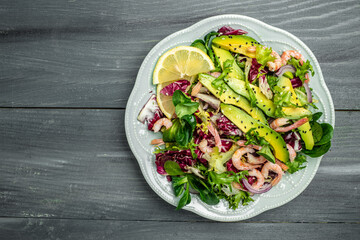 salad with fresh Avocado, Shrimps lettuce green mix and olive oil, lemon dressing. healthy food, Delicious breakfast or snack, Clean eating, dieting, vegan food concept. top view