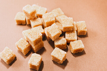 Brown sugar cubes close up on brown paper background
