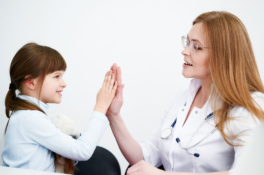 Creative professional female pediatric giving her little patient a high five