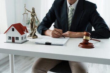 Law, Consultation, Agreement, Contract, Concept Attorney or lawyer focusing on the court hammer is sitting on the chair with a client's complaint to determine the house and land in court
