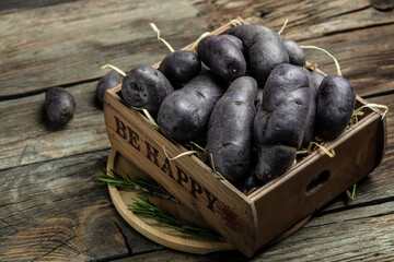 Raw purple sweet potato food . Fresh potatoes in an old sack on wooden background. Batata potato. vegan food ingredient. banner, menu, recipe place for text, top view