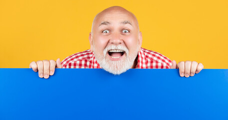 amazed senior man with copy space on blank banner
