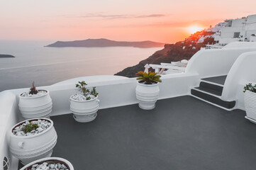 Beautiful sunset at Santorini island, Greece. White architecture with sea view. Summer travel and...