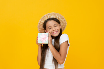 pleased teen child hold present box on yellow background