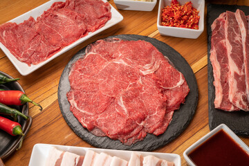 Mixed fresh Beef and pork belly set for BBQ grilling with Kimchi, fresh vegetables, fresh chili and dipping sauce, Korean BBQ.