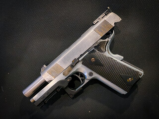 Old and dirty pistol gun on the fabric background