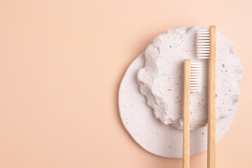 Taking care of the oral cavity. Wooden toothbrush on a concrete podium. Environmentally friendly personal hygiene products.