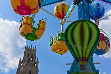 fun fair ride cars in the sky with Boston stump tower in background