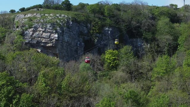 Great Orme suspended cable car journey along scenic Llandudno mountain aerial view tracking right shot