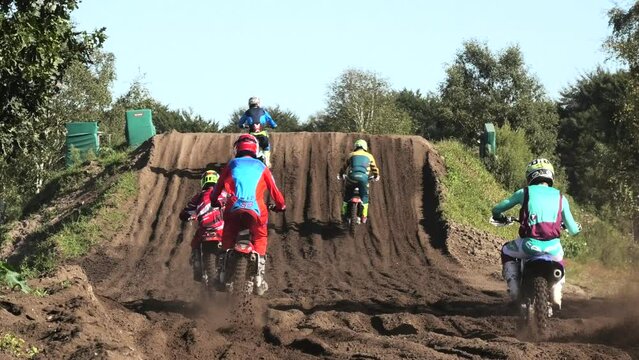 Dirt bikes jumping on motocross circuit in Arnhem, the Netherlands, seen from back