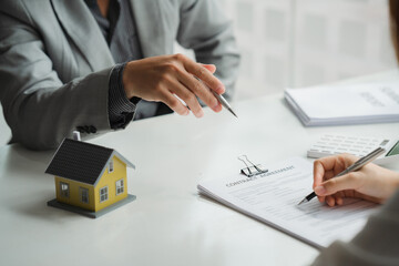 Real estate broker agent being analysis and making the decision a home estate loan to customer to signing contract documents for realty purchase, get insurance or loan real estate or property.