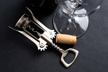 corkscrew with cork and wine glass