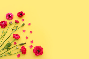 Top view image of pink flowers composition over yellow background