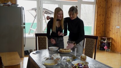Mom and daughter are preparing a cake together in the home kitchen.