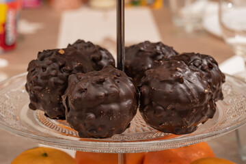 Marshmallows in chocolate in the form of balls lie on a plate.