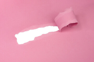 Hole in paper pink color background damaged ripped