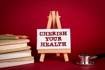 Cherish Your Health. Books and a doctor's stethoscope on a red background
