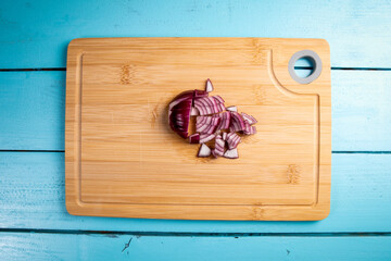 Cut onion into pieces on a bamboo cutting board