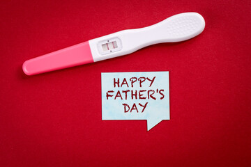 Happy father's day. Pregnancy test and speech bubble on a red background