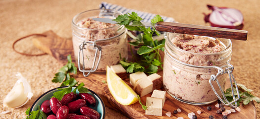 Healthy vegan pate in jars with bowl of kidney beans served on table