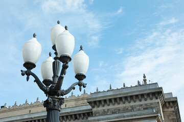 Fototapeta na wymiar Old fashioned street light lamp near building against cloudy sky