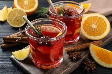 Aromatic punch drink and ingredients on black wooden table