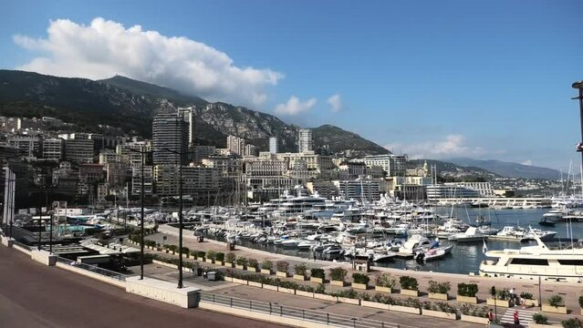 Wide panorama view on the Monaco harbour with the quay, condos and mountain in the background