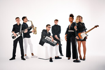 Portrait of diverse group of young people musical band playing with instruments - isolated on white background.