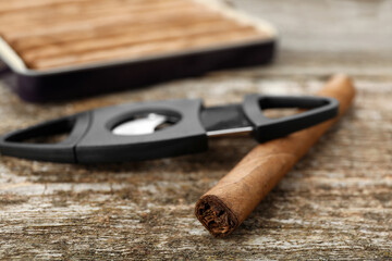 Cigar wrapped in tobacco leaf on wooden table, closeup