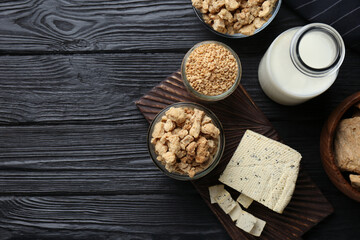 Different natural soy products on black wooden table, flat lay. Space for text