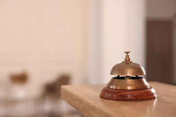 Hotel service bell on wooden reception desk. Space for text