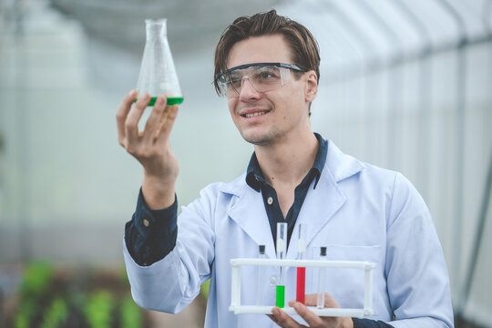 bio scientist in agriculture farm happy smile look at new chemical formula sample extract from plant farm concept.