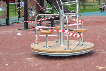Children's playground with carousels blocked by barricade tape