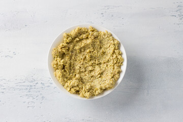 White bowl with soaked and ground green lentils on a light blue background. Cooking healthy vegan food