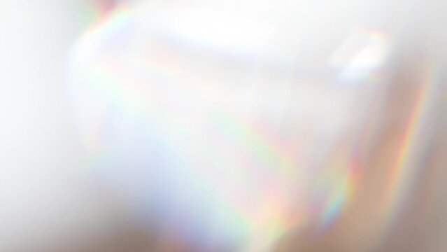 Slow Play Rainbow Crystal. Loop. The light passes through the facets of a slowly rotating diamond and creates repetitive sparkling highlights and rainbow colors