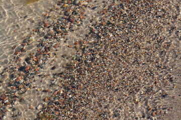 sand with small pebbles and shells on the seashore
